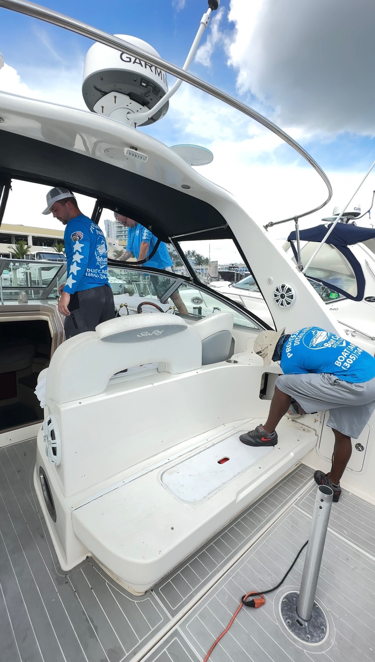 BoatCare360 team working on Sea Ray boat with hardtop open for interior cleaning